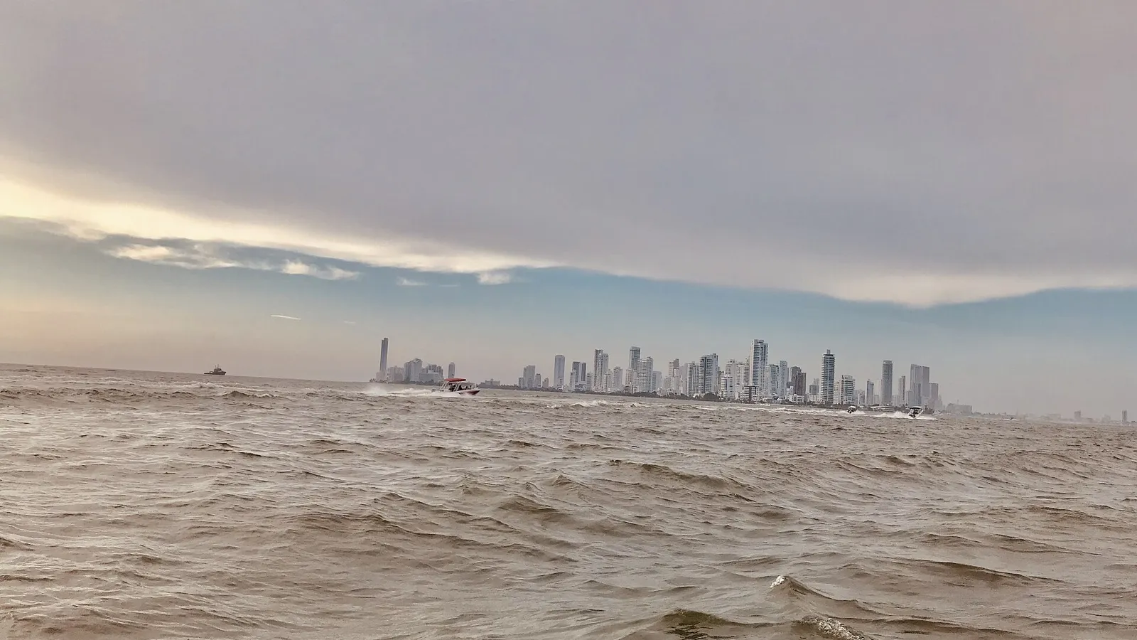 The Bocagrande skyline of Cartagena seen from the sea, with boats in the bay
