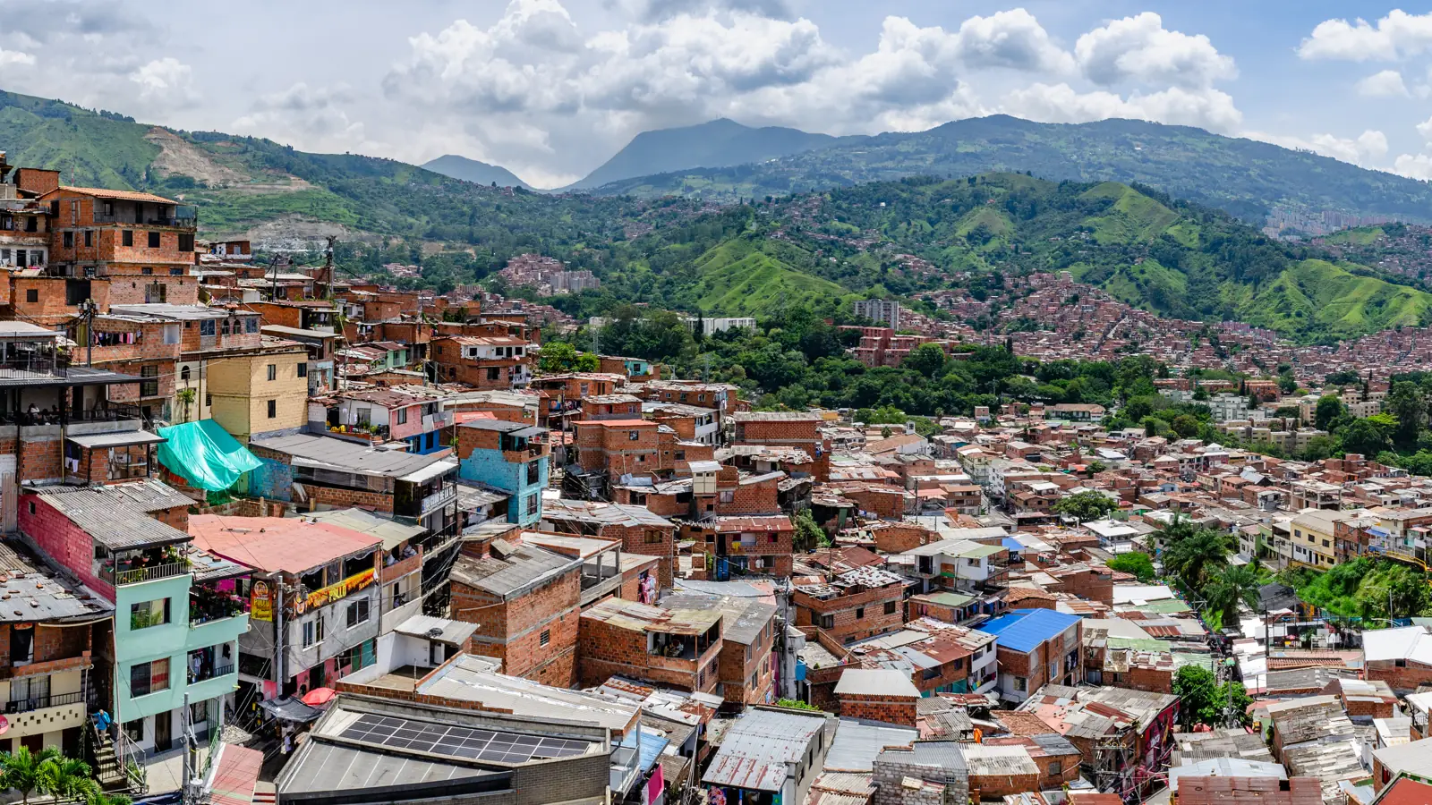 Hillside homes of San Javier (Comuna 13), Medellín, under a blue sky